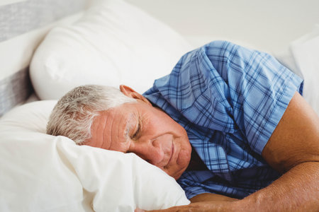 White duvet and pillows lying on bed under soft morning light with blue plaid, copy space. Bed, relaxation, comfort, wellness, minimalism, tranquility, homeの写真素材