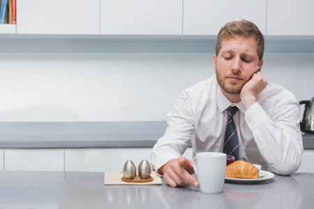 Adult man sitting at kitchen counter wearing dress shirt and tie, touching coffee mug, copy space. Minimalist, modern, office, professional, breakroom, contemplative, glossyの写真素材