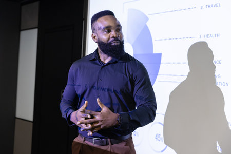 African American man in business attire presenting pie chart slide in conference room, copy space....