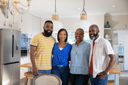 Diverse family standing in modern kitchen around island countertop with stools and pendant lamps....