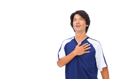 A man in a blue and white sports jersey is smiling and posing for a photo.