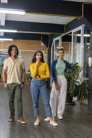 Diverse coworkers standing in modern open office by glass meeting rooms, smartwatch visible
