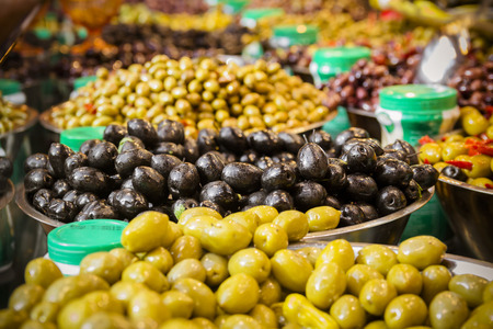 Olives at a market stall. A variety of types of olives. Green, black, Syrians and others.の写真素材
