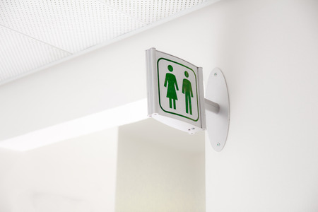 Public modern white and green restroom sign on white wallの写真素材