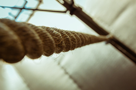 Brown climbing rope hanging from roof - Close up view from belowの写真素材