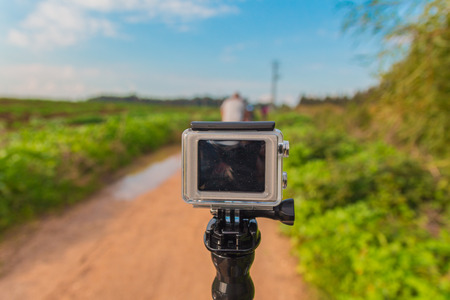 GoPro action camera on stick in dirt road at rural areaのeditorial素材