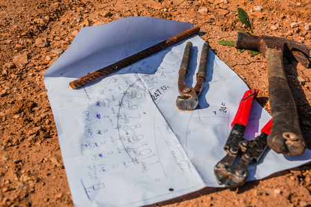 Construction plan and tools laid on the ground.の写真素材
