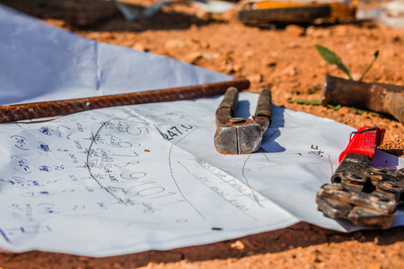 Construction plan and tools laid on the ground.の写真素材
