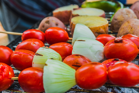 Tomato, onion and green chili pepper are cooked on the grill.の写真素材