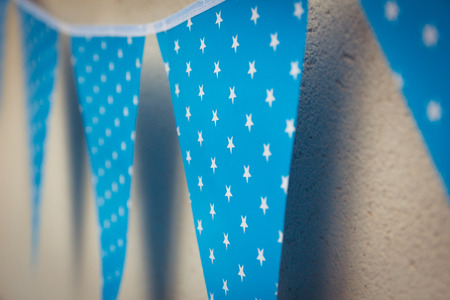 line of colorful blue party decorations flags with white stars illustration hanging from the wall.の写真素材