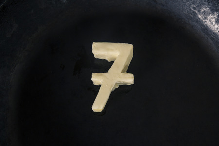 Butter in shape of number 7 on hot pan - Close up top viewの写真素材