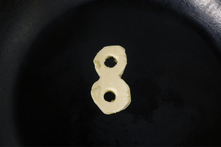 Butter in shape of number 8 on hot pan - Close up top viewの写真素材