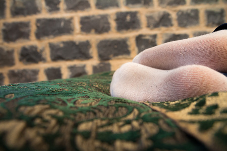 Legs of woman in white socks on bed.の写真素材