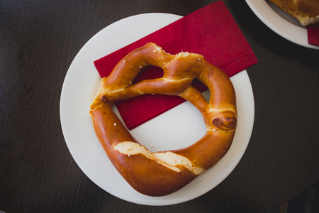Pretzel bread on white plate on wooden table.の写真素材