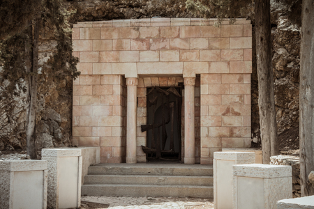 Entrance to an old small private bricks stone tomb carved into the mountain in israelのeditorial素材