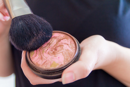Close up of woman hands holding makeup bronzer.の写真素材