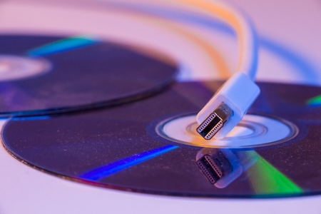 Closeup of white Mini Displayport cable with it's reflection on blank disc.