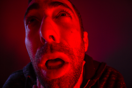 Depressed stressed man strangling himself. Close up headshot portrait of man chokesの写真素材