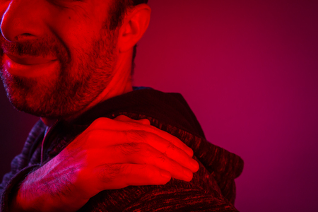 Man is suffering from back shoulder pain. Close up portrait of man.
の写真素材
