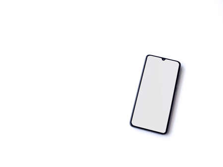 Black mobile smartphone mockup lies on the surface with blank screen isolated on white background....