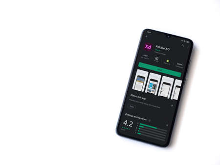 Lod, Israel - July 8, 2020: Adobe XD app play store page on the display of a black mobile smartphone isolated on white background. Top view flat lay with copy space.のeditorial素材