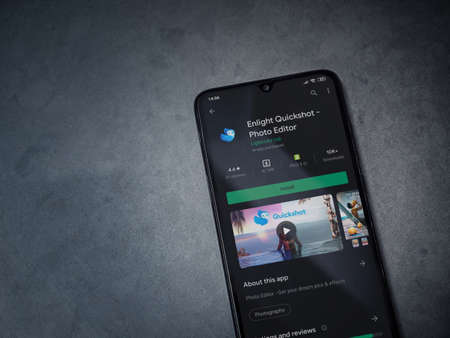 Lod, Israel - July 8, 2020: Enlight Quickshot app play store page on the display of a black mobile smartphone on a dark marble stone background. Top view flat lay with copy space.のeditorial素材