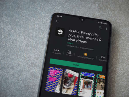 Lod, Israel - July 8, 2020: 9GAG app play store page on the display of a black mobile smartphone on ceramic stone background. Top view flat lay with copy space.のeditorial素材