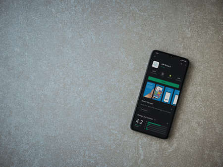 Lod, Israel - July 8, 2020: HP Smart app play store page on the display of a black mobile smartphone on ceramic stone background. Top view flat lay with copy space.のeditorial素材