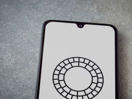 Lod, Israel - July 8, 2020: VSCO - Photo and Video Editor app launch screen with logo on the display of a black mobile smartphone on ceramic stone background. Top view flat lay with copy space.のeditorial素材