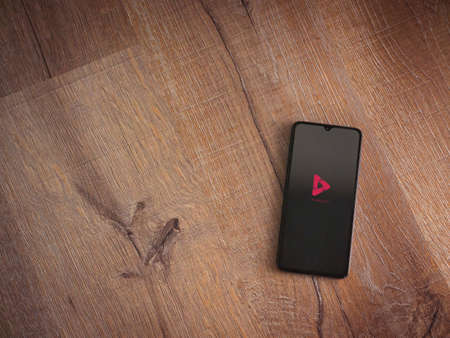 Lod, Israel - July 8, 2020: PixaMotion app launch screen with logo on the display of a black mobile smartphone on wooden background. Top view flat lay with copy space.のeditorial素材