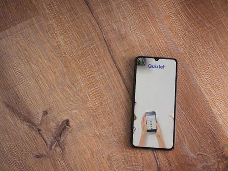 Lod, Israel - July 8, 2020: Quizlet - Language learning app launch screen with logo on the display of a black mobile smartphone on wooden background. Top view flat lay with copy space.のeditorial素材