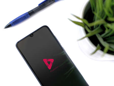 Lod, Israel - July 8, 2020: Modern minimalist office workspace with black mobile smartphone with...
