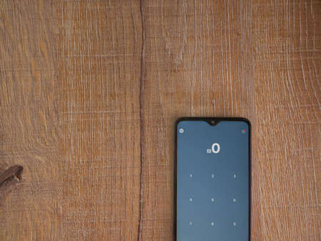 Lod, Israel - July 8, 2020: PAY app launch screen with logo on the display of a black mobile smartphone on wooden background. Top view flat lay with copy space.のeditorial素材