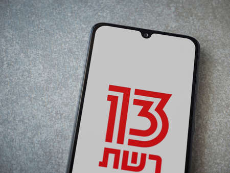 Lod, Israel - July 8, 2020: Reshet 13 app launch screen with logo on the display of a black mobile...