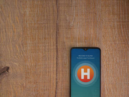 Lod, Israel - July 8, 2020: Helpers app launch screen with logo on the display of a black mobile...