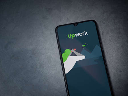 Lod, Israel - July 8, 2020: Upwork app launch screen with logo on the display of a black mobile...