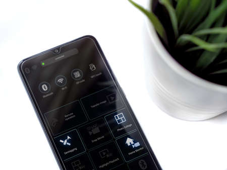 Lod, Israel - July 8, 2020: Modern minimalist office workspace with black mobile smartphone with...