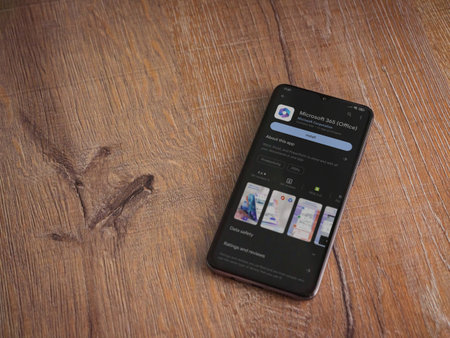 Lod, Israel - July 16,2023: Microsoft 360 app play store page on smartphone on wooden background. Top view flat lay with copy space.のeditorial素材