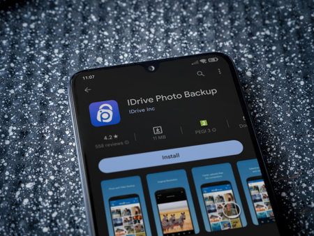 Lod, Israel - July 16,2023: IDrive Photo Backup app play store page on smartphone on a metallic background. Close up top view flat lay.のeditorial素材