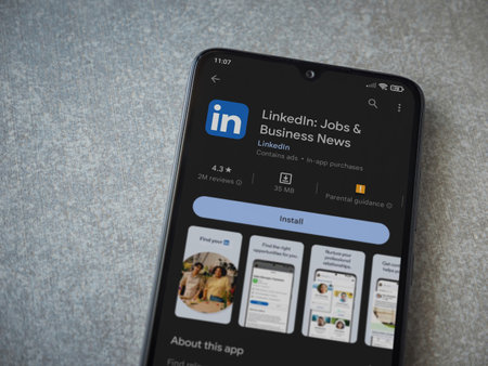 Foto de Lod, Israel - July 16,2023: LinkedIn app play store page on smartphone on ceramic stone background. Top view flat lay with copy space. - Imagen libre de derechos