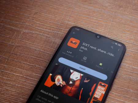 Lod, Israel - July 16,2023: SIXT rent app play store page on smartphone on wooden background. Top view flat lay with copy space.のeditorial素材