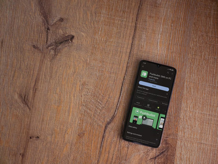 Lod, Israel - July 16,2023: Pushbullet app play store page on smartphone on wooden background. Top view flat lay with copy space.のeditorial素材