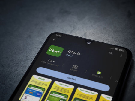 Lod, Israel - July 16,2023: iHerb app play store page on smartphone on a dark marble stone background. Top view flat lay with copy space.のeditorial素材