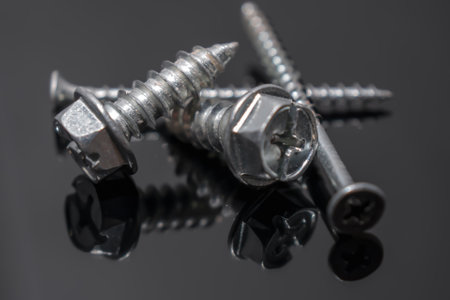 Screws placed on dark gray board. Close-up.の写真素材