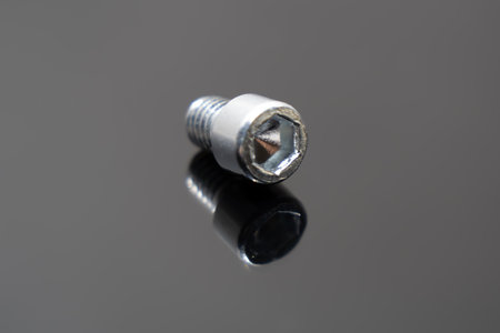 Hexagon socket head bolts placed on dark gray board. Close-up photo.の写真素材