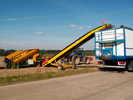 Pepingen, Belgium - September 29, 2015: Farmers harvest potatoes. They are using modern machinery to be more efficient.のeditorial素材