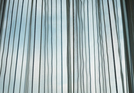 Window with texture curtain and blue skyの写真素材