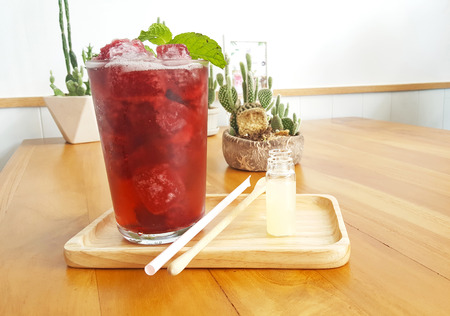 Refreshment iced roselle drink on wooden plate and table with mint leafの写真素材