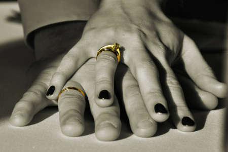 wedding rings on fingers in sepiaの写真素材