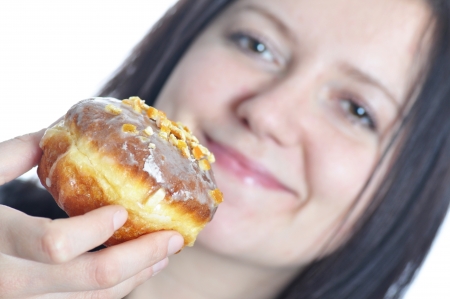 portrait of a young woman eating a donut against white backgroundの写真素材